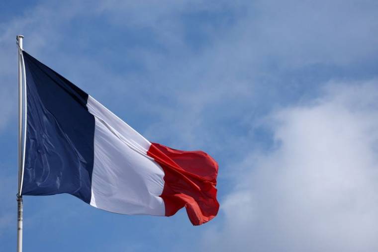 Photo du drapeau français qui flotte au-dessus du palais de l'Elysée à Paris