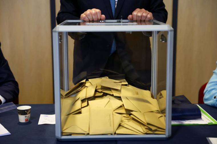 Un agent électoral se tient devant une urne lors de l'élection du Parlement européen, au Touquet-Paris-Plage