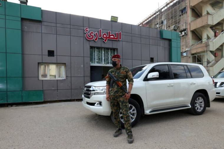 Un soldat posté devant l'entrée des urgences d'un hôpital de Hilla, où sont soignées des personnes blessées dans une explosion nocturne sur une base militaire en Irak, le 20 avril 2024 ( AFP / Karar Jabbar )