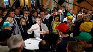 Le président de la République Emmanuel Macron discute avec les représentants des agriculteurs qui manifestent au Salon de l'agriculture, le 24 février 2024, à Paris ( POOL / Ludovic MARIN )