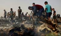 Des Palestiniens constatent les dégâts dans le camp pour personnes déplacées bombardé par l'armée israélienne à Rafah, dans le sud de la bande de Gaza, le 27 mai 2024 ( AFP / Eyad BABA )