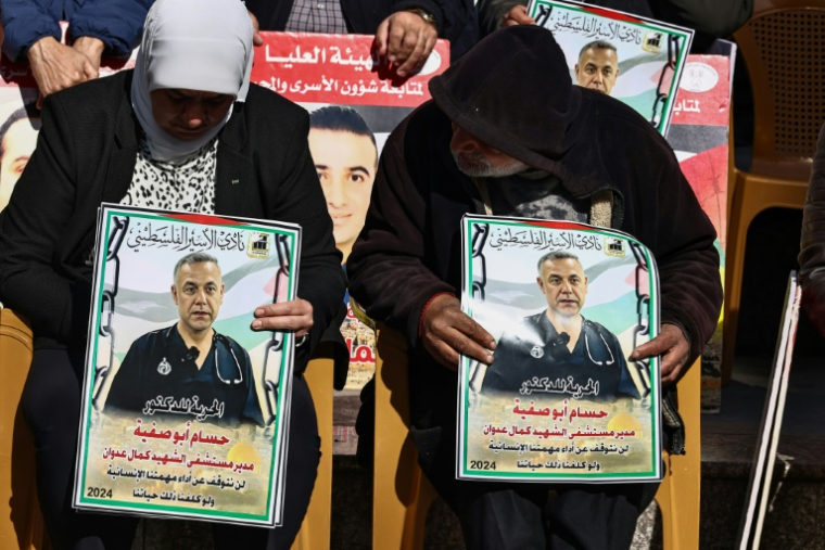 Des Palestiniens portent les portraits d'hommes détenus par Israël, à Ramallah, en Cisjordanie occupée, le 14 janvier 2025 ( AFP / Zain JAAFAR )