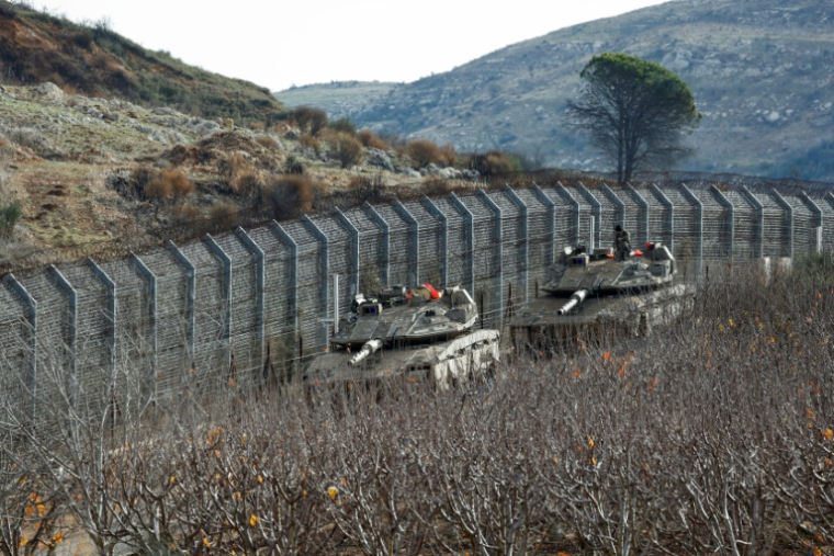 Des blindés israéliens stationnés près de la clôture séparant la partie du Golan occupée et annexée par Israël de la Syrie, le 10 décembre 2024 ( AFP / Jalaa MAREY )