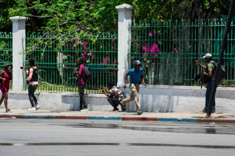 Des habitants fuient après avoir entendu des coups de feu provenant de gangs armés près du Palais national à Port-au-Prince, en Haïti, le 2 avril 2024 ( AFP / Clarens SIFFROY )
