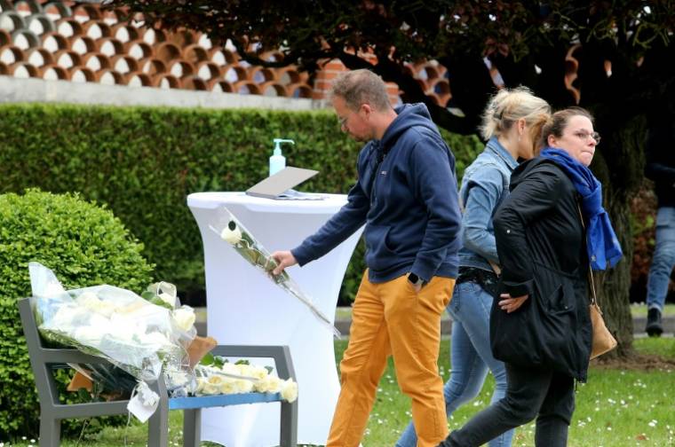 Des fleurs sont déposées sur un banc devant l'hôpital universitaire de Reims le 23 mai 2023 en hommage à l'infirmière de l'établissement tuée ( AFP / FRANCOIS NASCIMBENI )