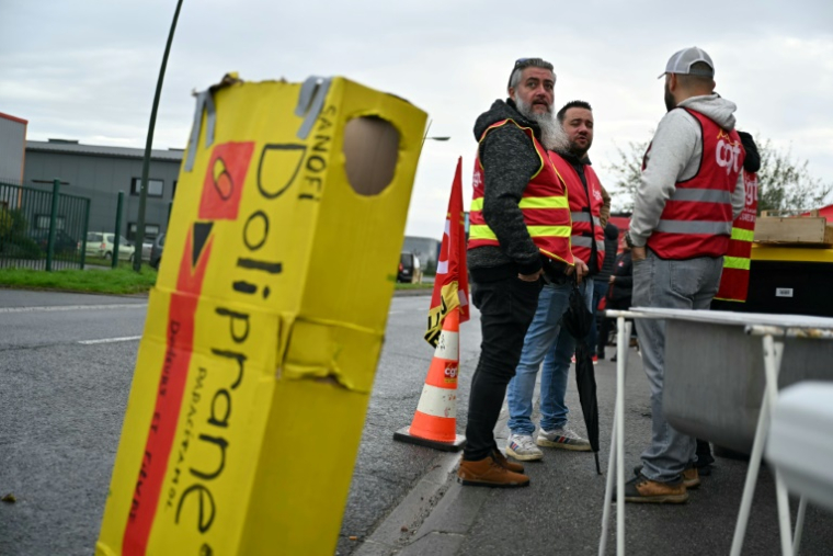 Des employés et des syndicalistes en grève devant leur usine qui fabrique le Doliprane à Lisieux (nord-ouest de la France), après l'annonce par Sanofi de négociation en cours avec le fonds d'investissement américain CD&R afin de lui céder potentiellement 50% de la  d'Opella, sa filiale qui commercialise notamment ce paracétamol en France. Photo prise le 17 octobre ( AFP / LOU BENOIST )