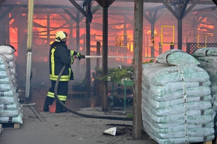 Un pompier ukrainien éteint un incendie dans un hypermarché après une frappe russe à Kharkiv, le 25 mai 2024 ( AFP / SERGEY BOBOK )