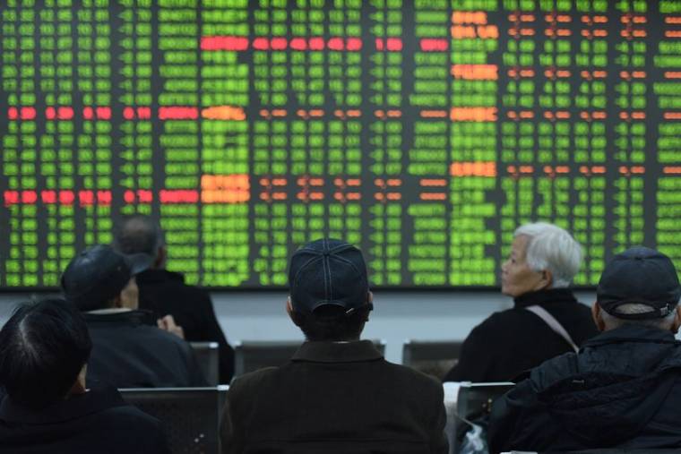 Photo d'archives des investisseurs devant un tableau comportant des informations boursières en Chine