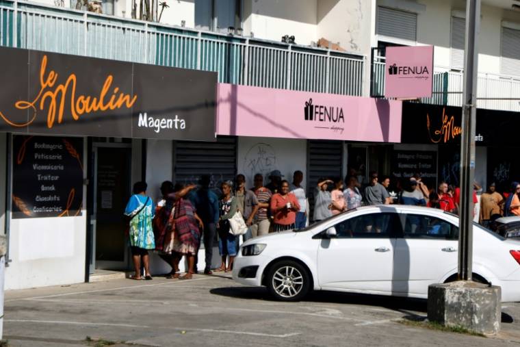 Des habitants font la queue pour acheter du pain dans le quartier de Magenta, à Nouméa, le 23 mai 2024 en Nouvelle-Calédonie  ( POOL / Ludovic MARIN )