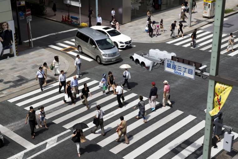 Des personnes traversent une rue dans le quartier de Ginza à Tokyo, au Japon