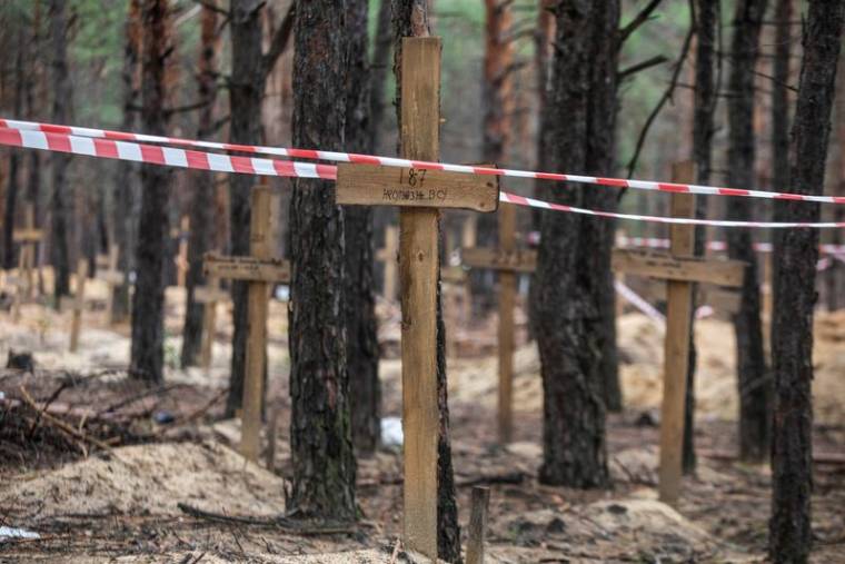 Ruban de signalisation sur une tombe d'un soldat ukrainien non identifié dans un cimetière improvisé dans la ville d'Izium