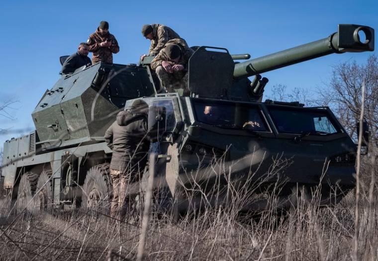 Des militaires ukrainiens se préparent à tirer un obusier automoteur Dana