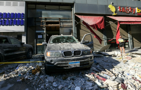 Une voiture détruite sur le site d'une frappe aérienne israélienne dans la banlieue sud de Beyrouth, le 26 septembre 2024 ( AFP / Ibrahim AMRO )