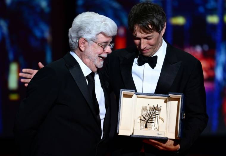 Le cinéaste américain Sean Baker (D), Palme d'or du festival de Cannes pour "Anora", pose aux côtés du réalisateur américain George Lucas, le 25 mai 20245 à Cannes  ( AFP / Christophe SIMON )