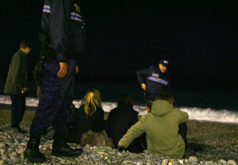 Des policiers parlent avec des jeunes sur la plage à Nice, où le maire a ordonné un couvre-feu nocturne pour les enfants de moins de 13 ans, le 4 décembre 2009 ( AFP / STEPHANE DANNA )