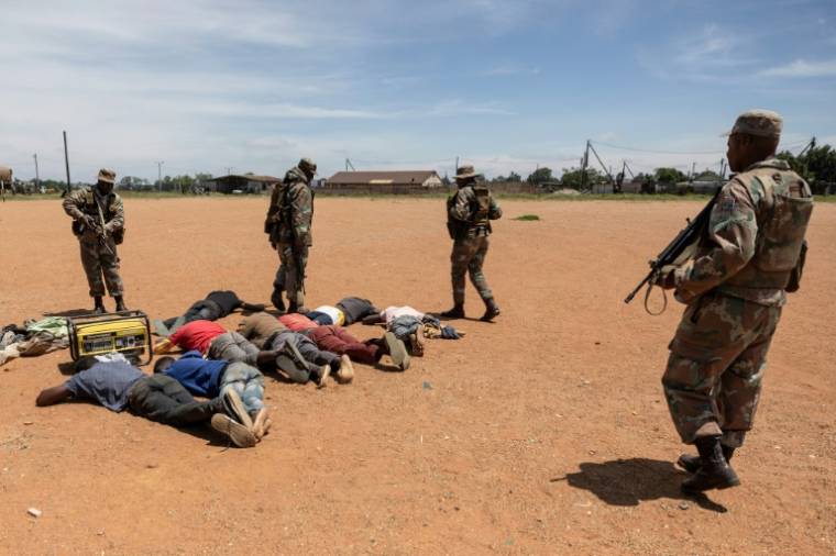 Des soldats sud-africains arrêtent des "zama zamas" le 14 décembre 2024 près de Kagiso ( AFP / WIKUS DE WET )