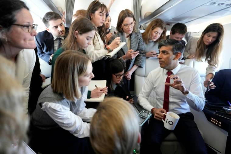 Le Premier ministre britannique Rishi Sunak répond aux questions des journalistes l'accompagnant à bord de l'avion à destination de Varsovie, le 23 avril 2024 ( POOL / Alastair Grant )