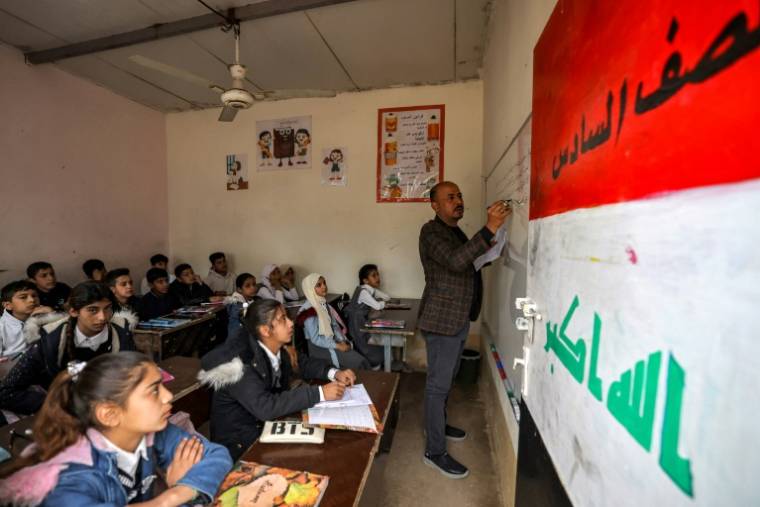 Des élèves suivent un cours dans une salle de classe d'une école située dans le centre de l'Irak, le 10 mars 2024 ( AFP / AHMAD AL-RUBAYE )