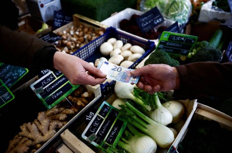 Un client achète des légumes dans un marché local à Nantes