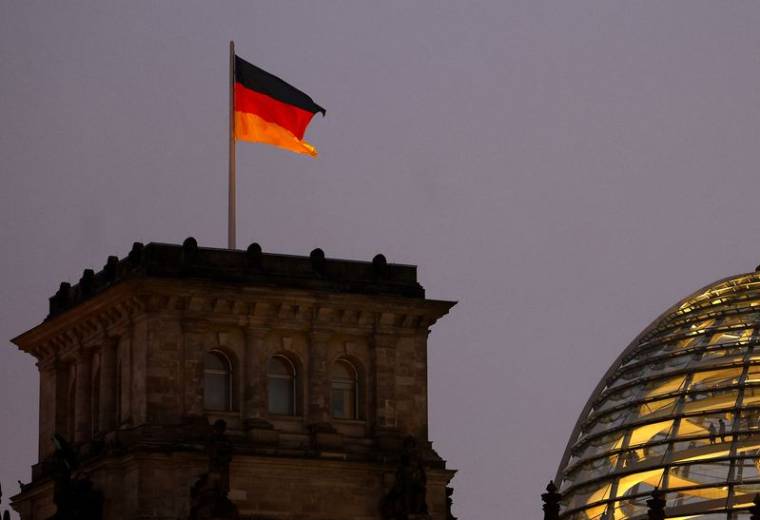 Un drapeau allemand flotte sur le bâtiment illuminé du Reichstag, à Berlin