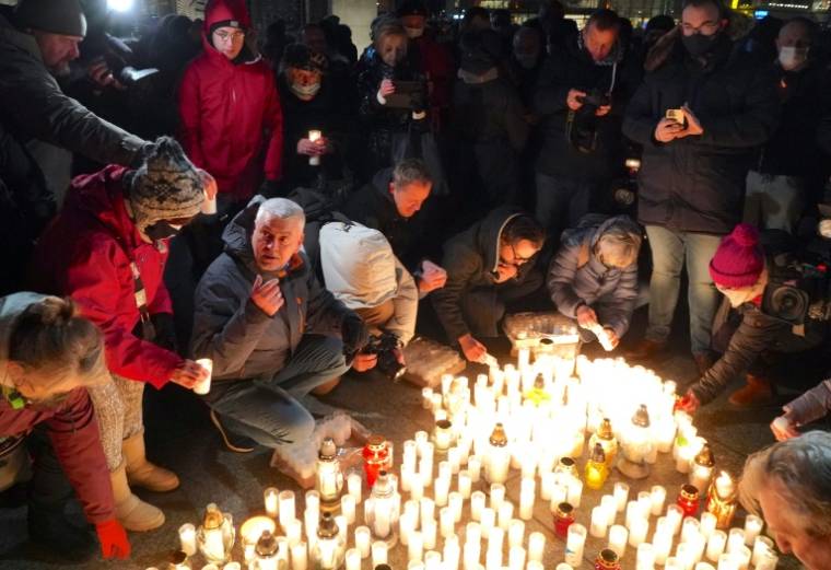 Des passants allument des bougies pour commémorer les décès dus au COVID-19, à Varsovie, le 11 janvier 2022                    ( AFP / JANEK SKARZYNSKI )