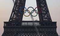 Des équipes finissent d'accrocher les anneaux olympiques à la tour Eiffel, le 7 juin 2024, à Paris ( AFP / JOEL SAGET )