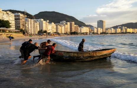 Des pêcheurs prennent l'eau depuis la plage de Copacabana, à Rio de Janeiro, au Brésil, le 23 mai 2023 ( AFP / CARL DE SOUZA )