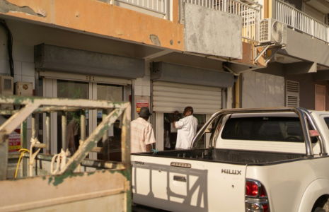 Un boucher rouvre manuellement le rideau métallique de son magasin du Moule, en Guadeloupe, le 26 octobre 2024, à la suite d'une panne d'électricité générale ( AFP / Brian Nocandy )