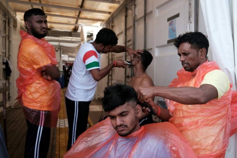 Des migrants originaires du Bangladesh participent à un atelier de coiffure à bord du navire-ambulance Ocean Viking, le 21 mai 2024. ( AFP / Clément MELKI )