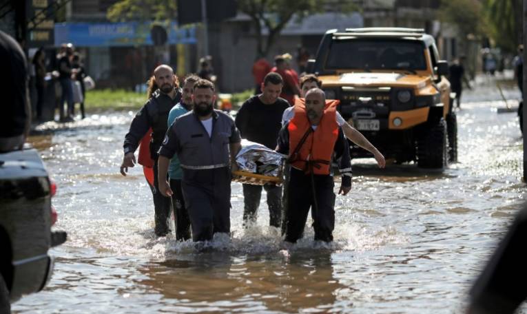 Une habitante est transportée sur une civière après avoir été évacuée du quartier de Sarandi inondé, le 5 mai 2024 à Porto Alegre, dans l'Etat du Rio Grande do Sul, au Brésil ( AFP / Anselmo Cunha )