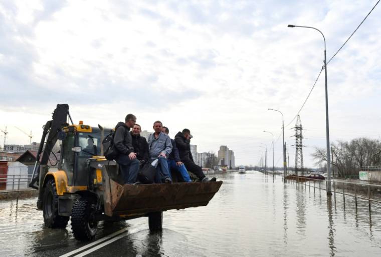 Moyens de transports improvisés dans la ville inondée d'Orenbourg, en Russie, le 13 avril 2024 ( AFP / Olga MALTSEVA )