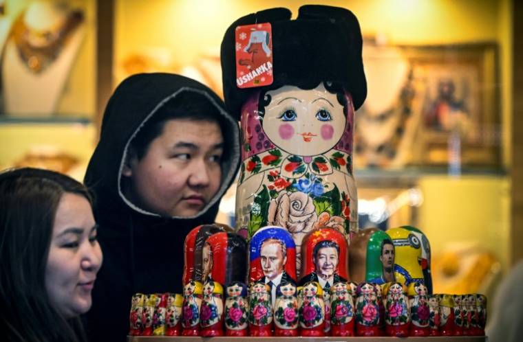 Des touristes regardent des poupées russes à l'effigie de Xi Jinping et Vladimir Poutine, à Moscou le 15 novembre 2023 ( AFP / Alexander NEMENOV )