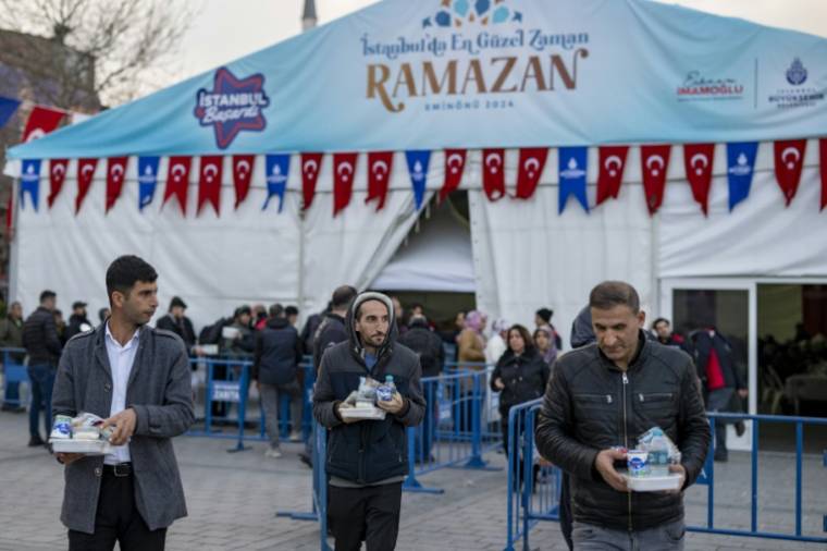 Des fidèles repartent avec un repas pour l'iftar offert par la municipalité d'Istanbul, pendant le mois du ramadan, le 15 mars 2024 en Turquie ( AFP / Yasin AKGUL )