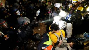 Des policiers font face aux étudiants pro-palestiniens après avoir détruit une partie de la barricade érigée sur le campus de l'Université de Californie à Los Angeles (UCLA), le 2 mai 2024 ( AFP / Etienne LAURENT )