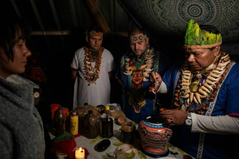 Le chaman colombien Claudino Perez (d) sert du yage ou de l'ayahuasca lors d'une cérémonie à La Mesa, dans le département de Cundinamarca, en Colombie, le 9 mars 2024 ( AFP / Luis ACOSTA )