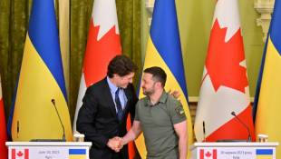 Le président ukrainien Volodymyr Zelensky (D) et le Premier ministre canadien Justin Trudeau se serrent la main après la signature d'accords bilatéraux à Kiev ( AFP / Sergei SUPINSKY )