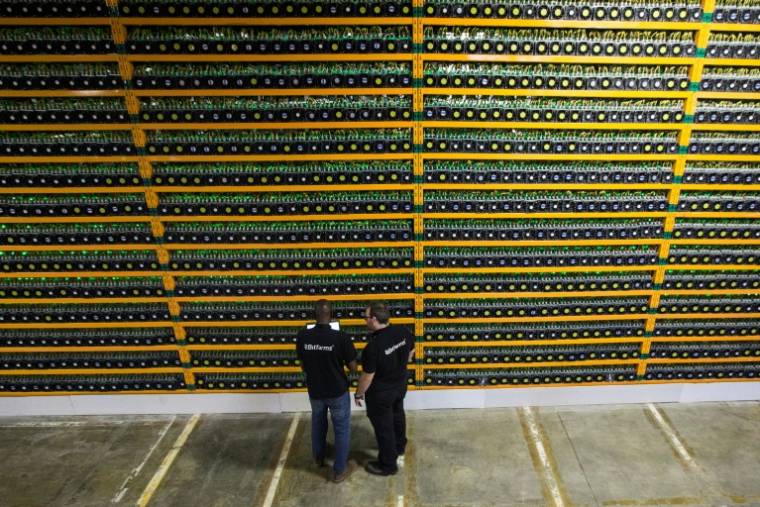 Des techniciens inspectent l'installation de minage de Bitcoin chez Bitfarms, le 19 mars 2018 à Saint Hyacinthe, au Québec ( AFP / Lars Hagberg )