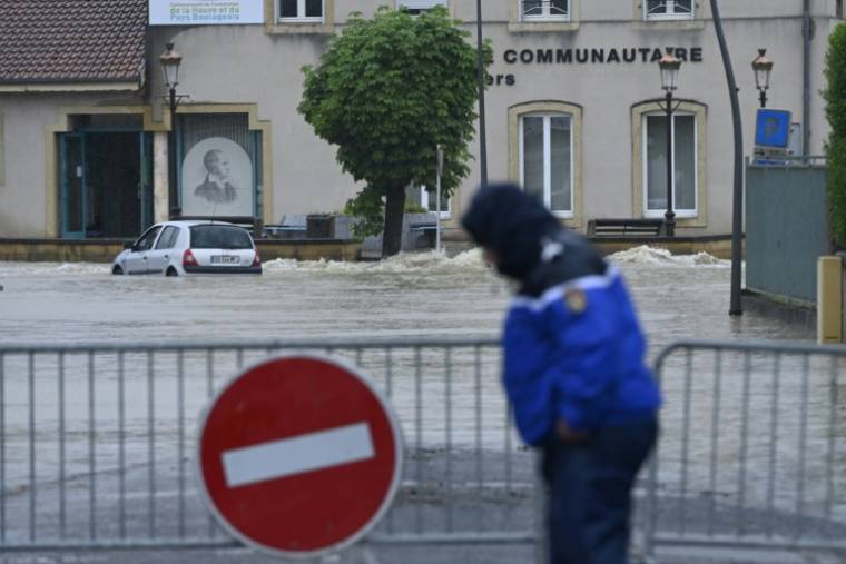 Un policier devant un périmètre interdit en raison des inondations à Boulay-Moselle, en Moselle, le 17 mai 2024 ( AFP / Jean-Christophe VERHAEGEN )