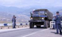 Un camion de soldats de maintien de la paix russes traverse la frontière du côté azerbaïdjanais devant les forces de police arméniennes (d) près de Kornidzor, le 22 septembre 2023 en Arménie ( AFP / ALAIN JOCARD )