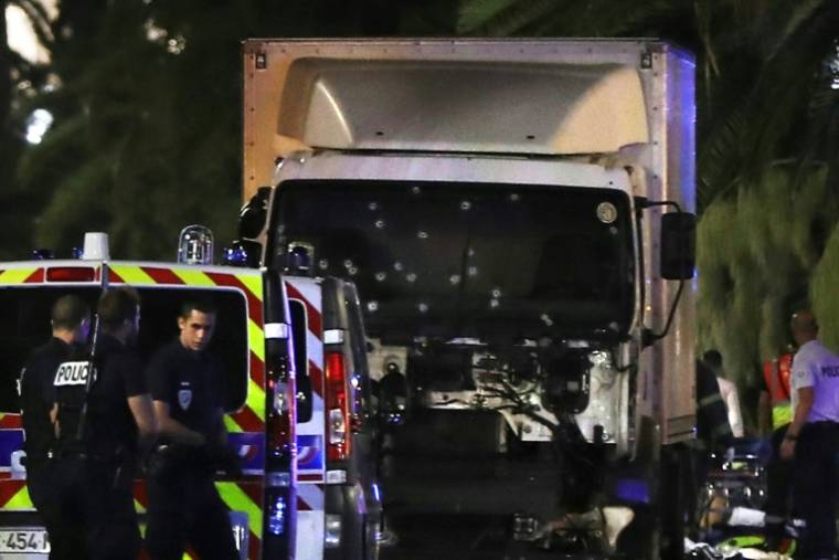 Des policiers entourent le camion à bord duquel l'auteur de l'attentat de Nice a foncé dans la foule sur la Promenade des Anglais, le 14 juillet 2016 ( AFP / VALERY HACHE )