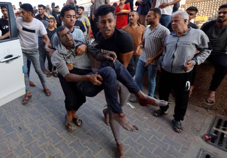 Des civils palestiniens portant un blessé après une frappe israélienne à Khan Younis, au sud de Gaza