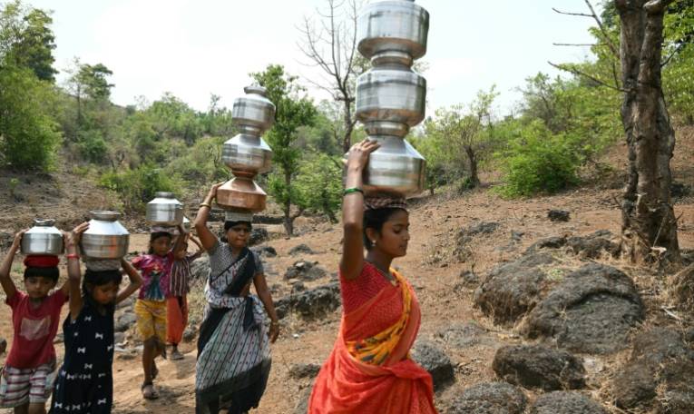Des villageoises portent des pots d'eau dans le district de Shahapur, dans l'Etat du Maharashtra, le 26 mai 2024 en Inde ( AFP / Indranil MUKHERJEE )