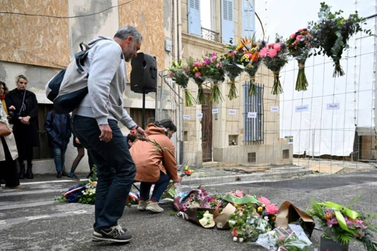 Des gens déposent des fleurs lors d'une cérémonie commémorative marquant la date anniversaire du bâtiment qui s'est effondré dans la rue Tivoli à Marseille, dans le sud de la France, le 9 avril 2024 ( AFP / Nicolas TUCAT )