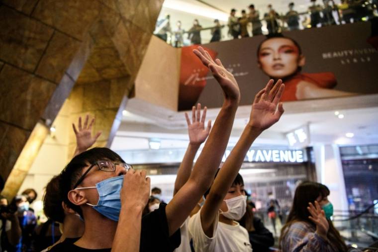 Des manifestants anti-gouvernementaux chantent l'hymne "Glory to Hong Kong" lors d'un rassemblement dans un centre commercial, le 13 mai 2020 à Hong Kong ( AFP / Anthony WALLACE )