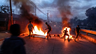 Des manifestants sur un barrage en feu à Maputo, le 23 décembre 2024 ( AFP / Amilton Neves )