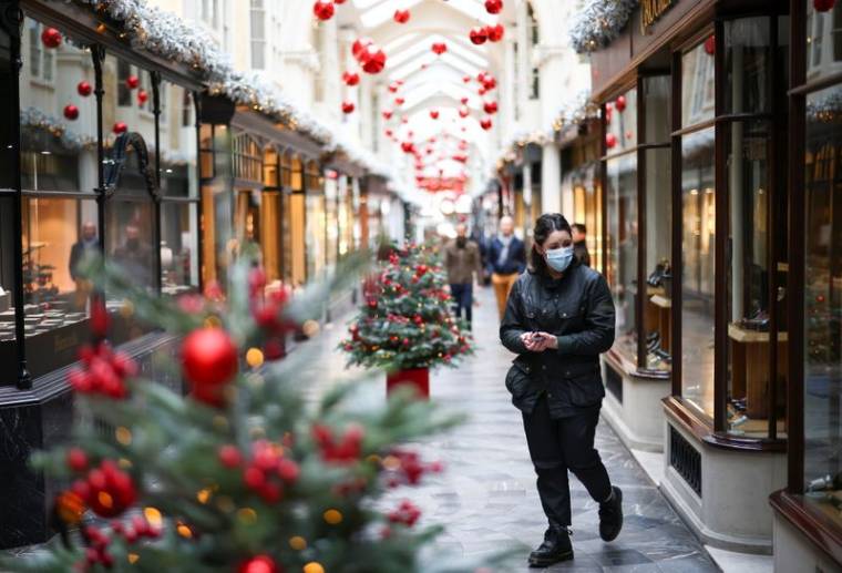 Woman walks through the Burlington Arcade adorned with Christmas decorations, in London