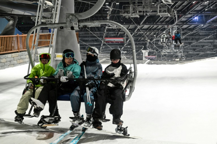 Des skieurs sur le télésiège de la plus grande piste de ski intérieure au monde, au L*SNOW Indoor Skiing Theme Resort, le 6 septembre 2024 à Shanghai ( AFP / Hector RETAMAL )