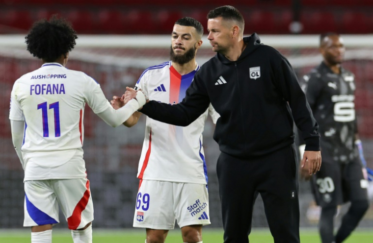 L'entraîneur de l'OL Pierre Sage serre la main de l'attaquant lyonnais Malik Fofana à la fin de la rencontre contre Rennes au Roazhon Park le 18 août 2024 à Rennes en France  ( AFP / FRED TANNEAU )