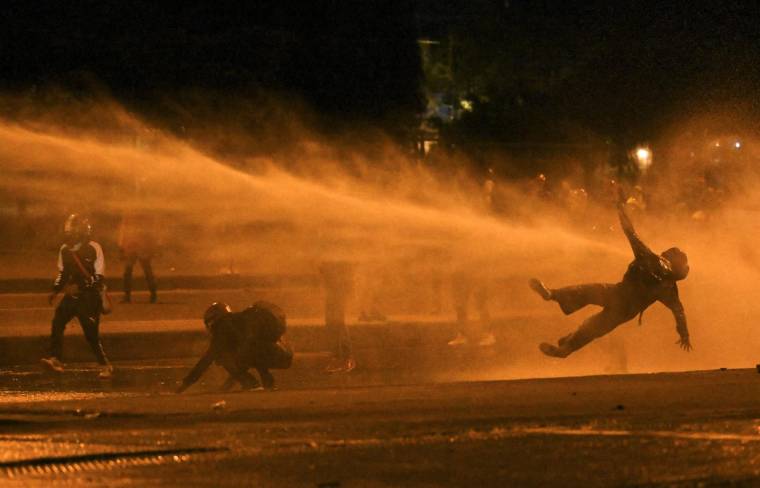 Un manifestant est touché par un canon à eau lors d'affrontements avec la police anti-émeute lors de manifestations contre le gouvernement du président colombien Ivan Duque, à Bogotá, le 12 juin 2021.  ( AFP / JUAN BARRETO )
