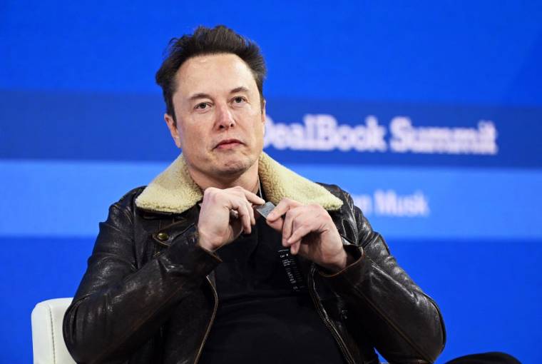 Elon Musk porte un collier en l'honneur des otages israéliens sur scène lors du New York Times Dealbook Summit 2023, le 29 novembre 2023 à New York.  ( GETTY IMAGES NORTH AMERICA / SLAVEN VLASIC )